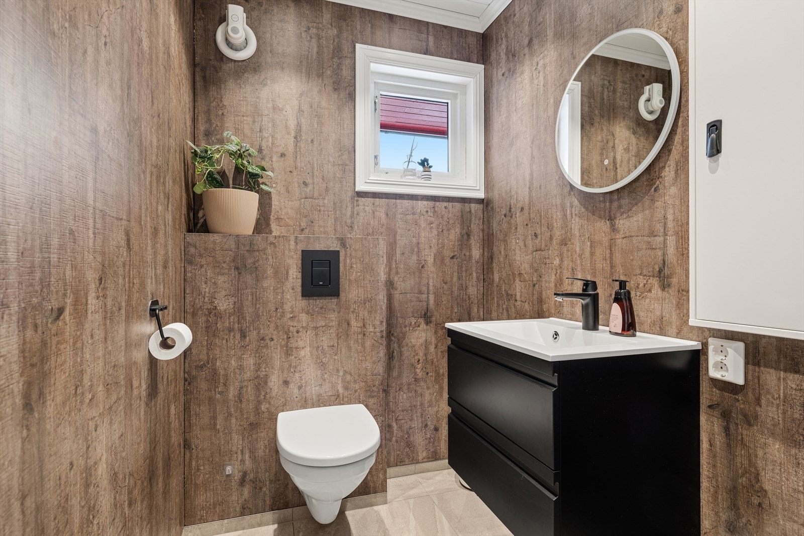 Toalettrom med wc og vask. Rommet er pusset opp i 2021 med fliser på gulv, baderomsplater på vegger og smartpanel i himling. Galleribilde