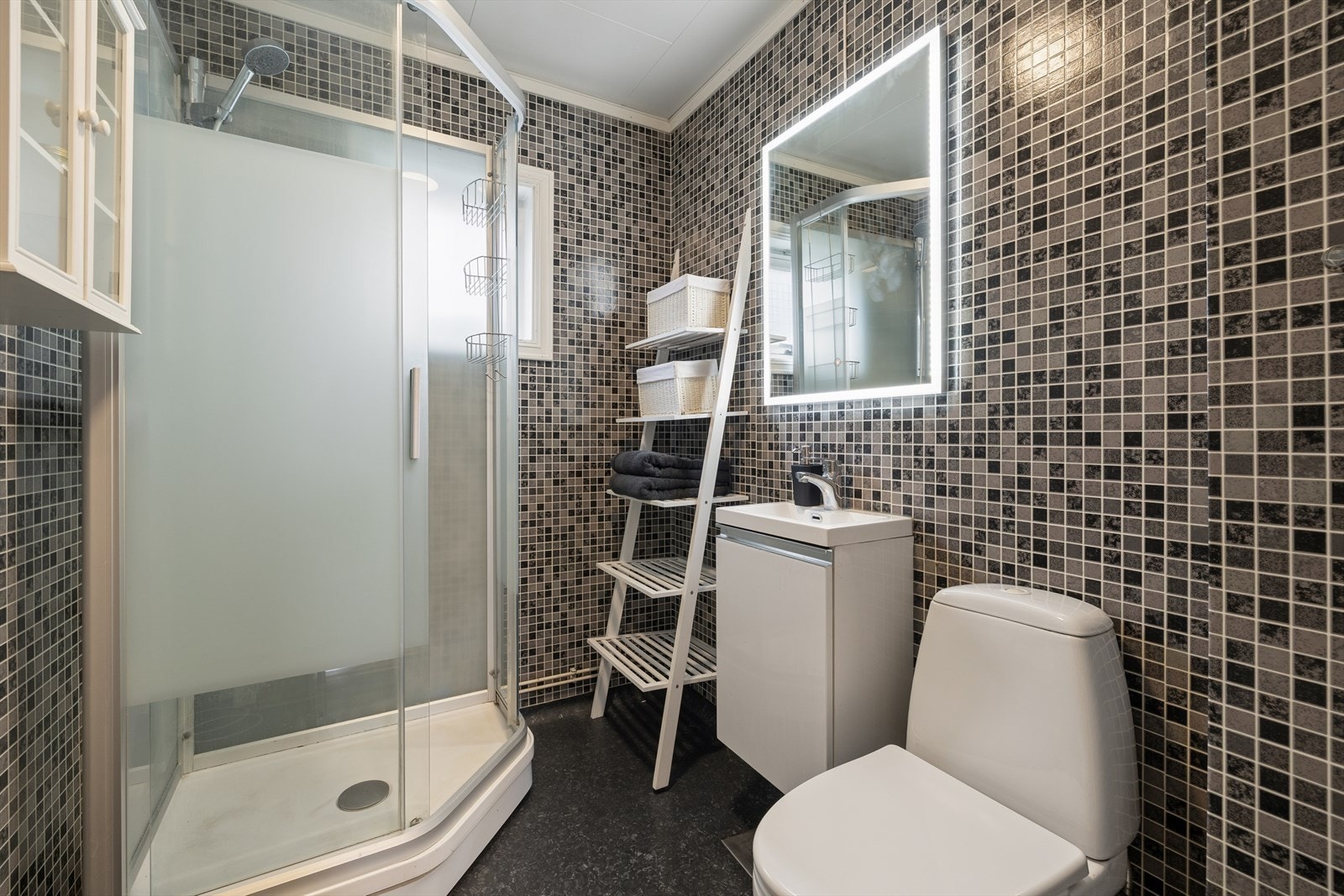 Badet er innredet med servant, toalett og dusjkabinett Galleribilde