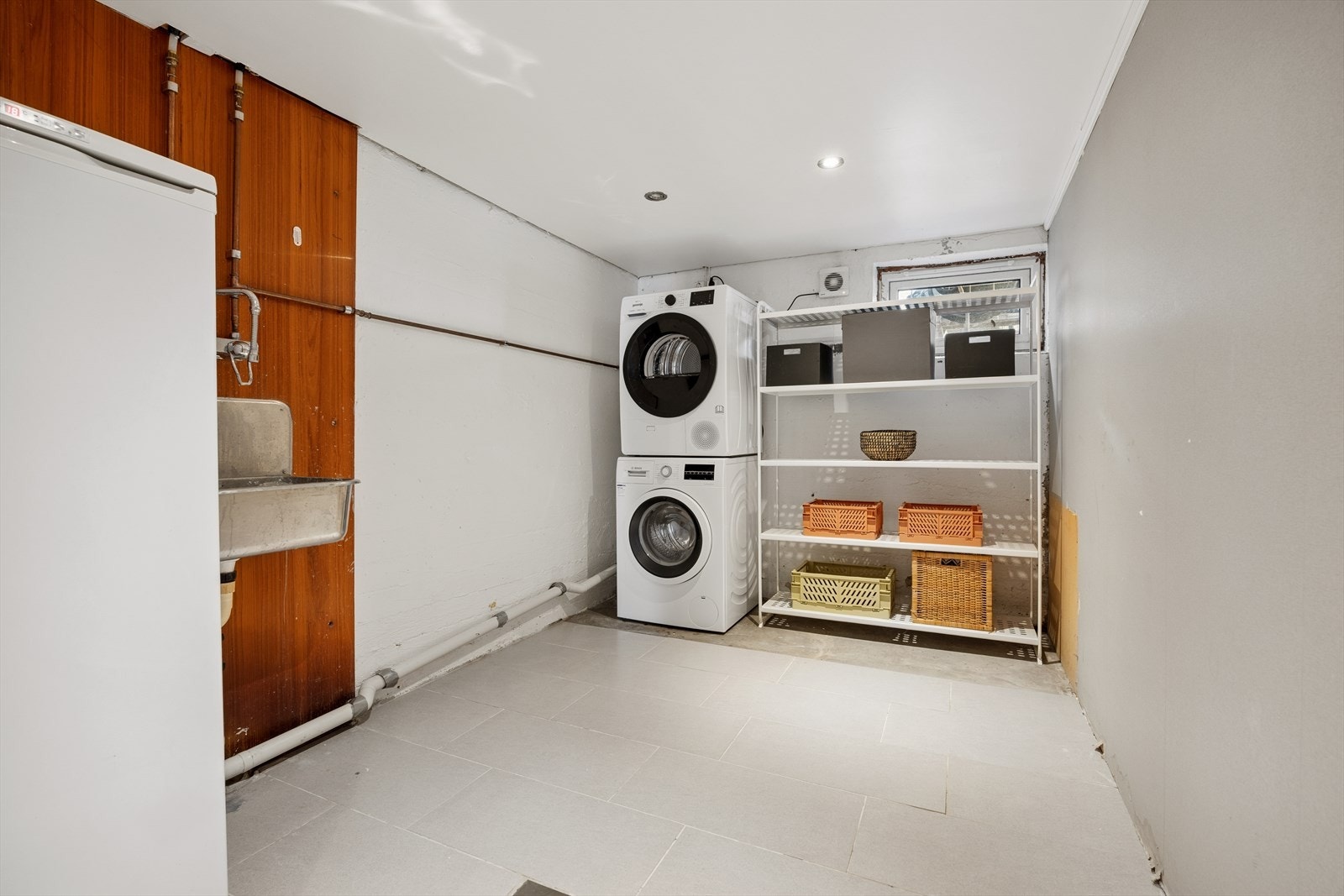 Praktisk vaskerom i kjelleren med opplegg for vaskemaskin og utslagsvask. Galleribilde