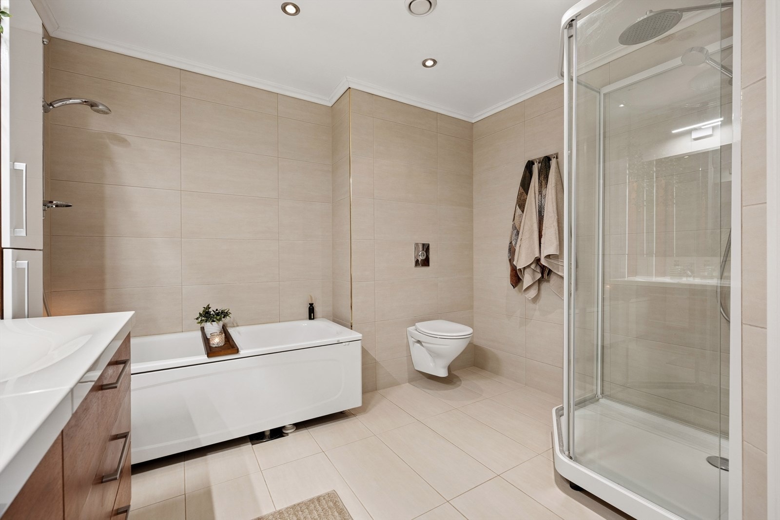 Veggmontert toalett, badekar og dusjkabinett. Spotter i taket. Galleribilde