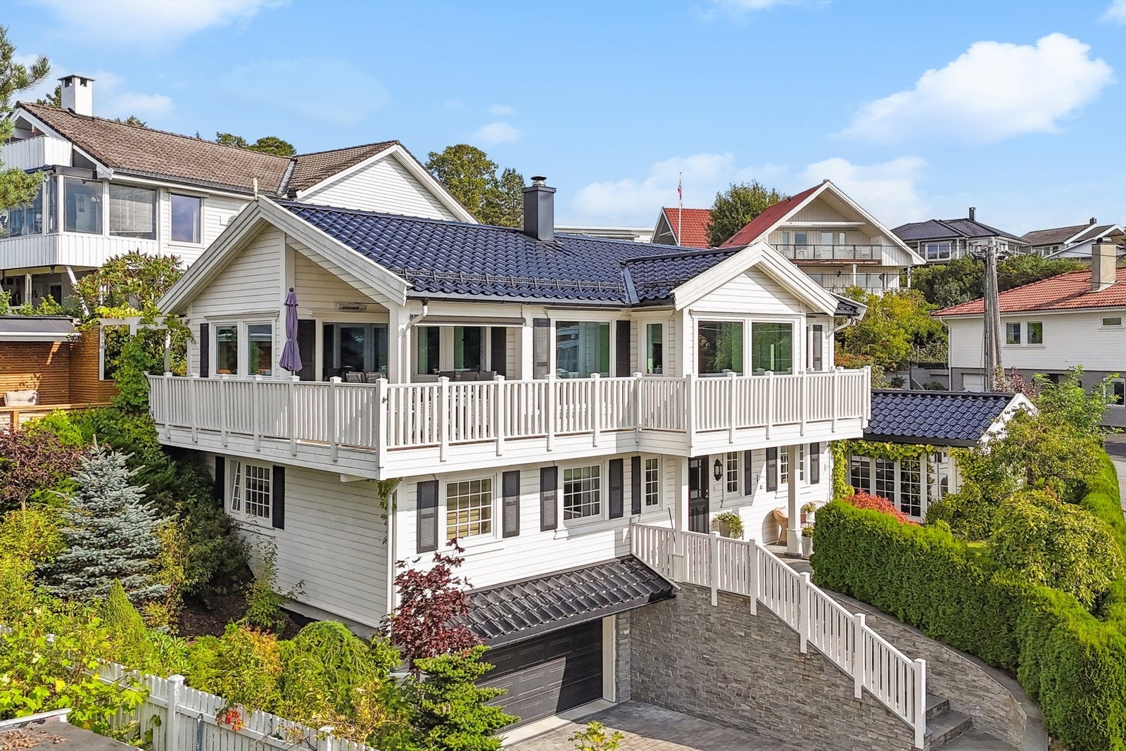 Flere uteplasser med terrasse i 1. etasje, uteplass på nordvestsiden på ca. 12 m², stor skiferbelagt uteplass ved inngangspartiet og hage med plenarealer og lysthus. Galleribilde