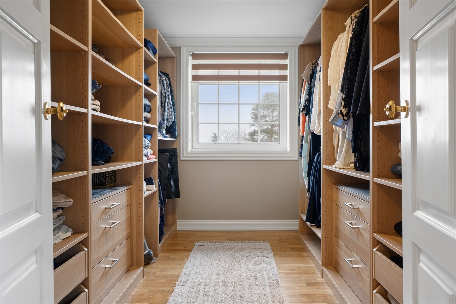 Praktisk walk-in closet med gjennomtenkte løsninger - rikelig med hyller, skuffer og heng som gir perfekt orden og luksuriøs hverdagskomfort. Galleribilde