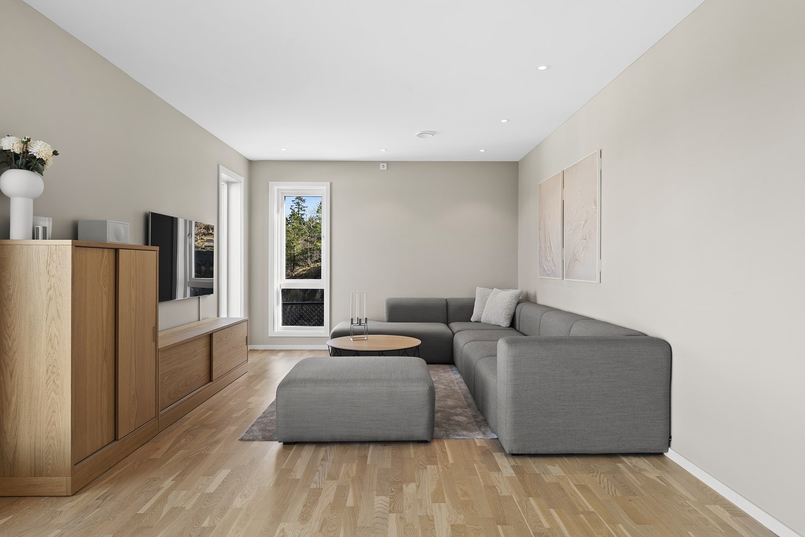 Stuen bærer preg av moderne og gjennomtenkte løsninger, med listefrie overganger og store vindusflater ut mot Frierfjorden. Galleribilde