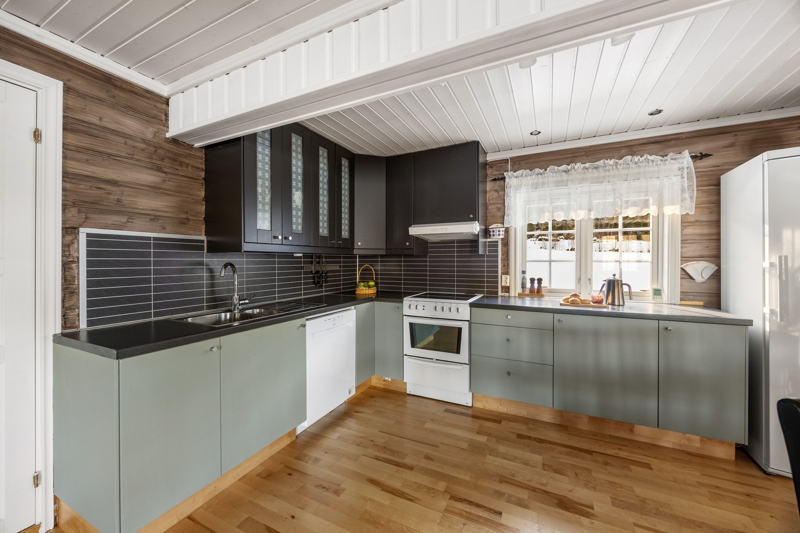 Stilren kjøkkeninnredning med avsatt plass for hvitevarer Galleribilde