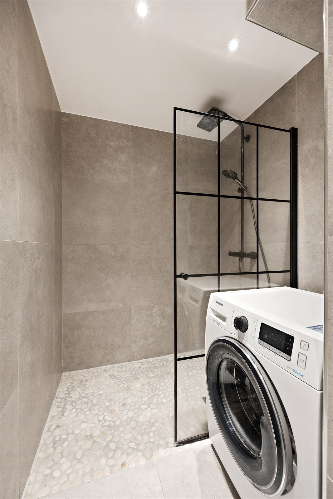 Dusjsonen har dekorative steiner på gulvet og en stilren dusjvegg i glass. Galleribilde