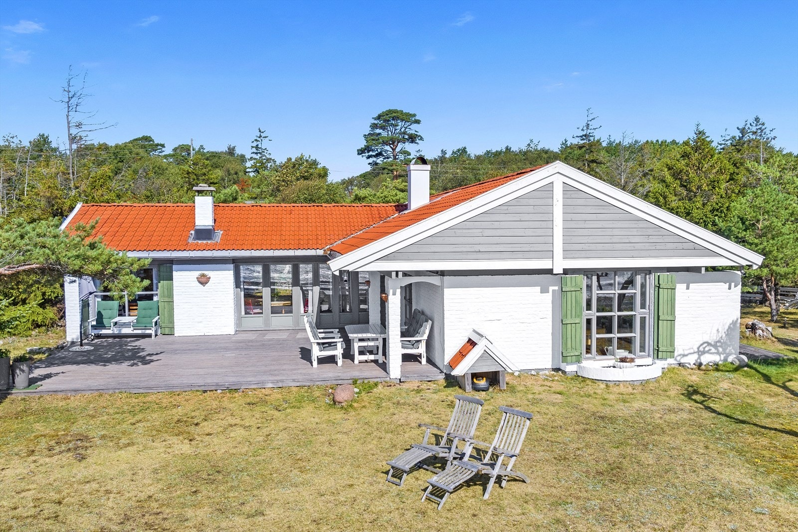 Foran hytta er det stor terrasse og plen. Galleribilde