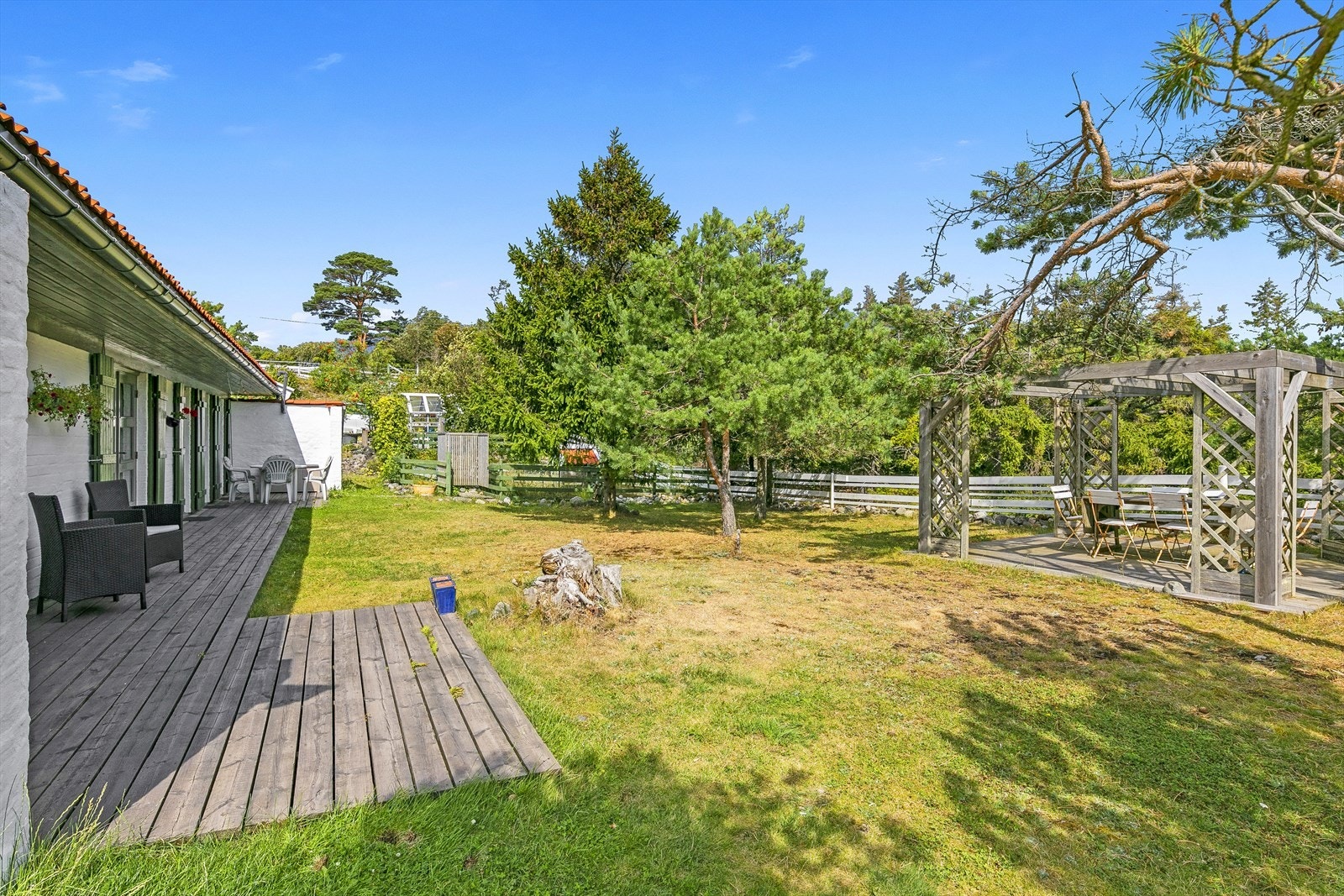 På nordøstsiden av tomten er det kjøkkenhage, utedusj, uteplass med pergola samt drivhus. Galleribilde