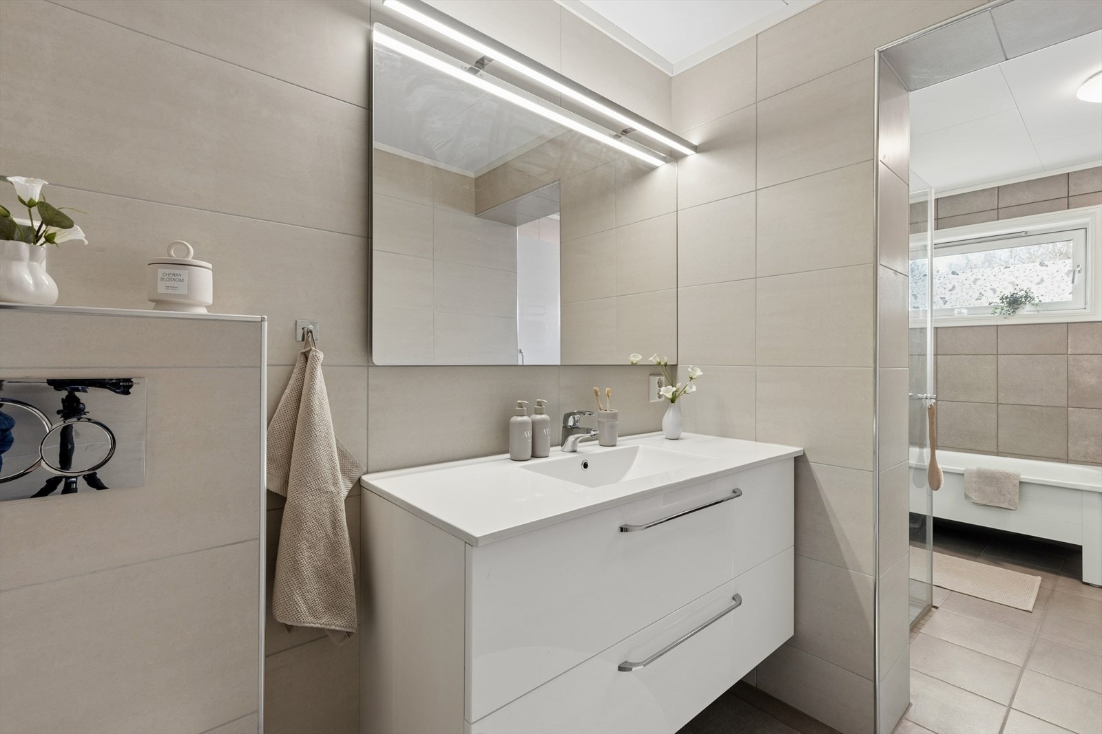 Badet i hoveddelen av boligen ble tilbygget i 1986 og modernisert i 2015. Innredningen består av en hel, nedfelt servant i servantskap, vegghengt toalett med dusj- og tørkefunksjon. Galleribilde