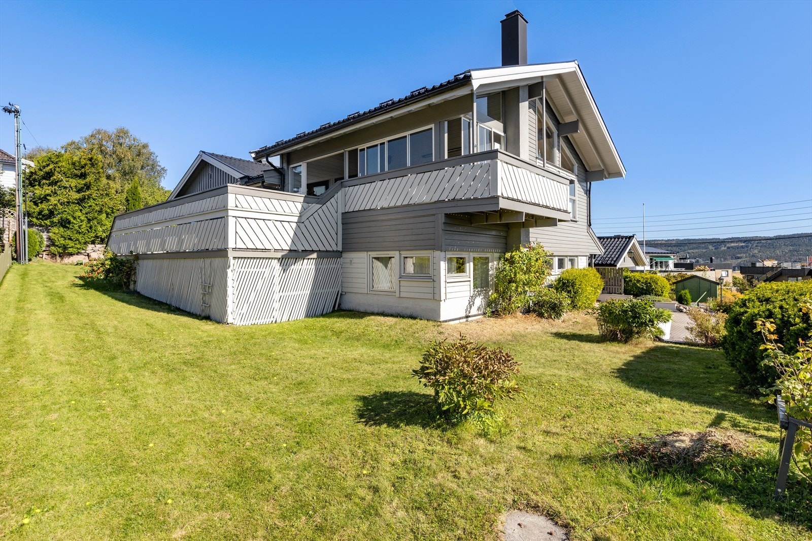 Tomta er skrånende ned mot sør og pent opparbeidet med plen, prydbusker og bærbusker. Lavt lagringsareal under terrassen. Galleribilde