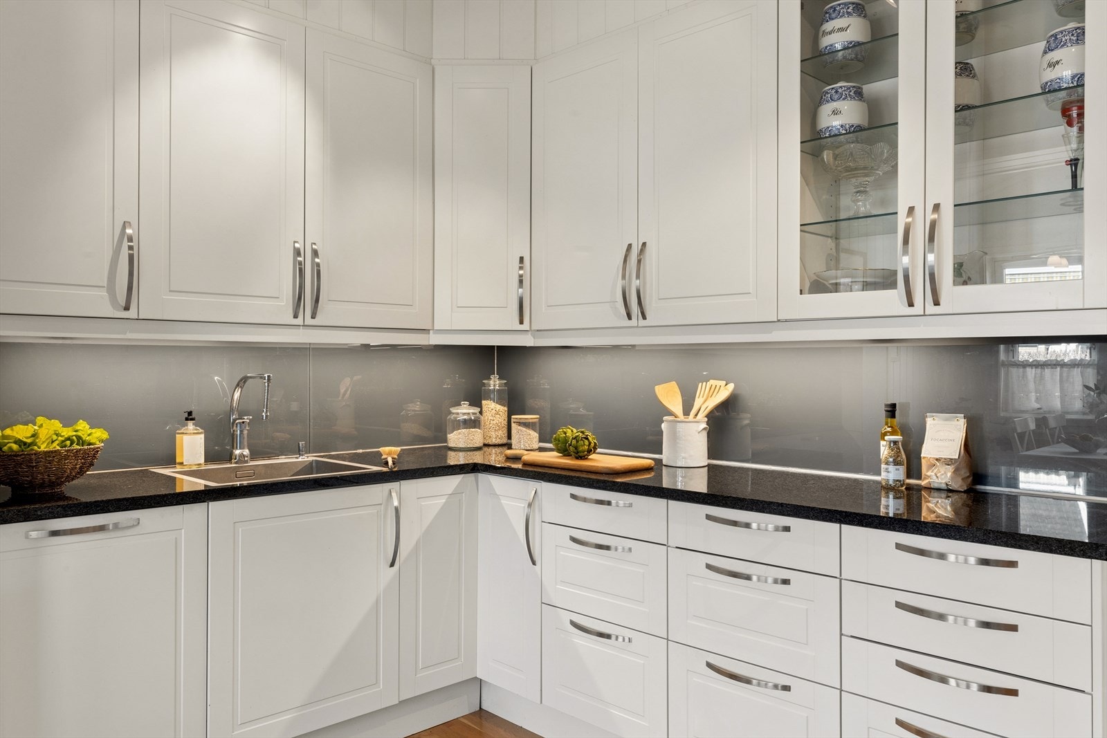 Solid benkeplate i stein, og fliser samt glassplate over benken. Galleribilde