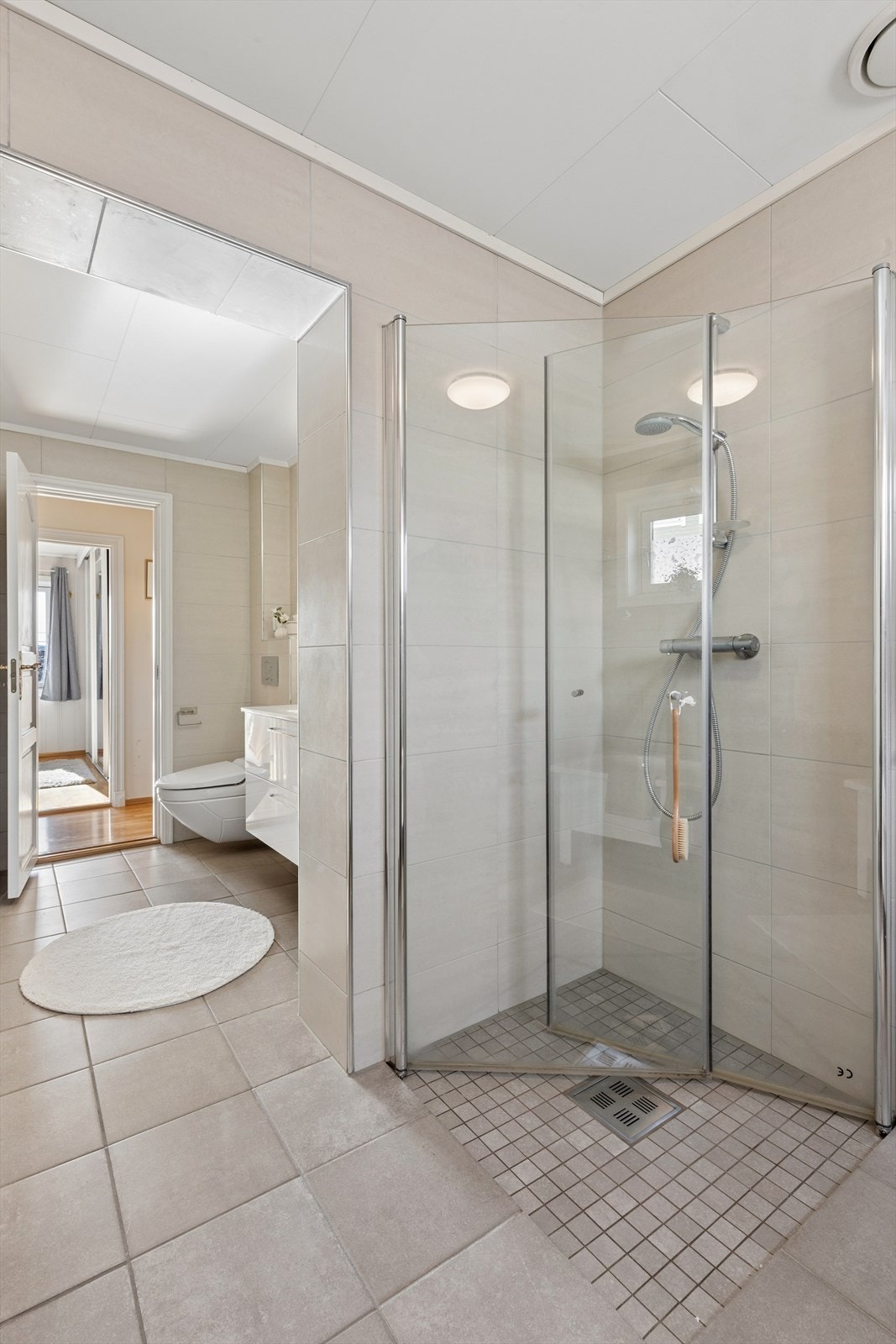 Dusjsonen er nedsenket og elegant utført med mosaikkfliser, i tillegg til plassbesparende og foldbare dusjvegger. Galleribilde