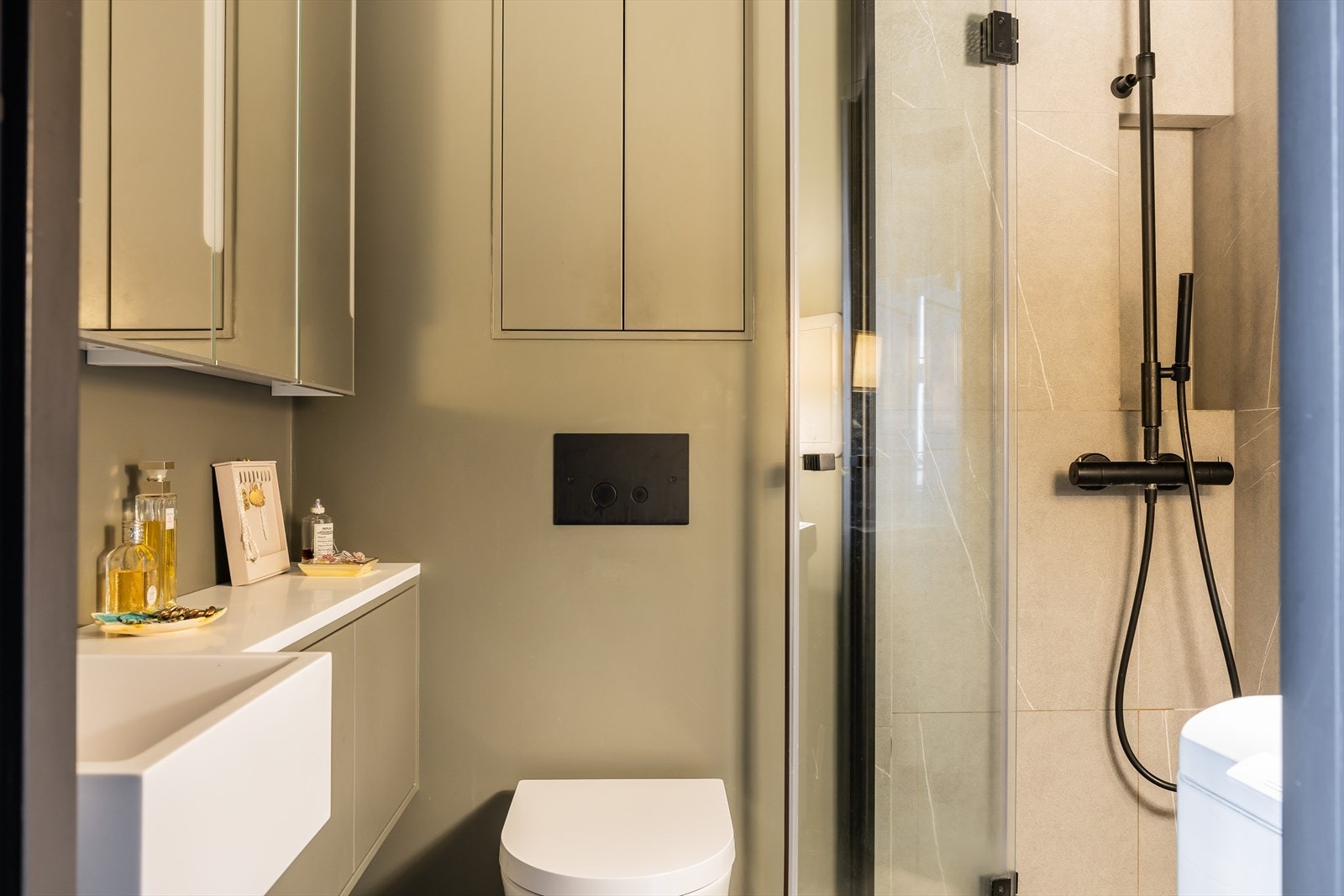 Pent baderom fra 2019 utstyrt med vegghengt toalett og dusjhjørne med innfellbare glassvegger. Galleribilde