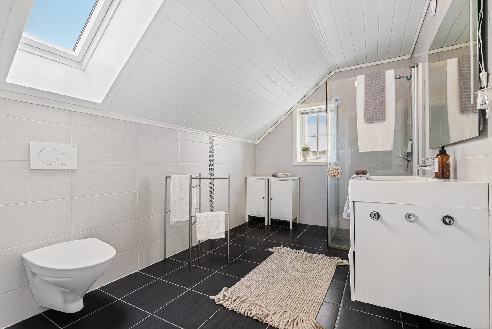 Badet har et areal på 7,79 m² og har takvindu for mer lysinnslipp. Galleribilde