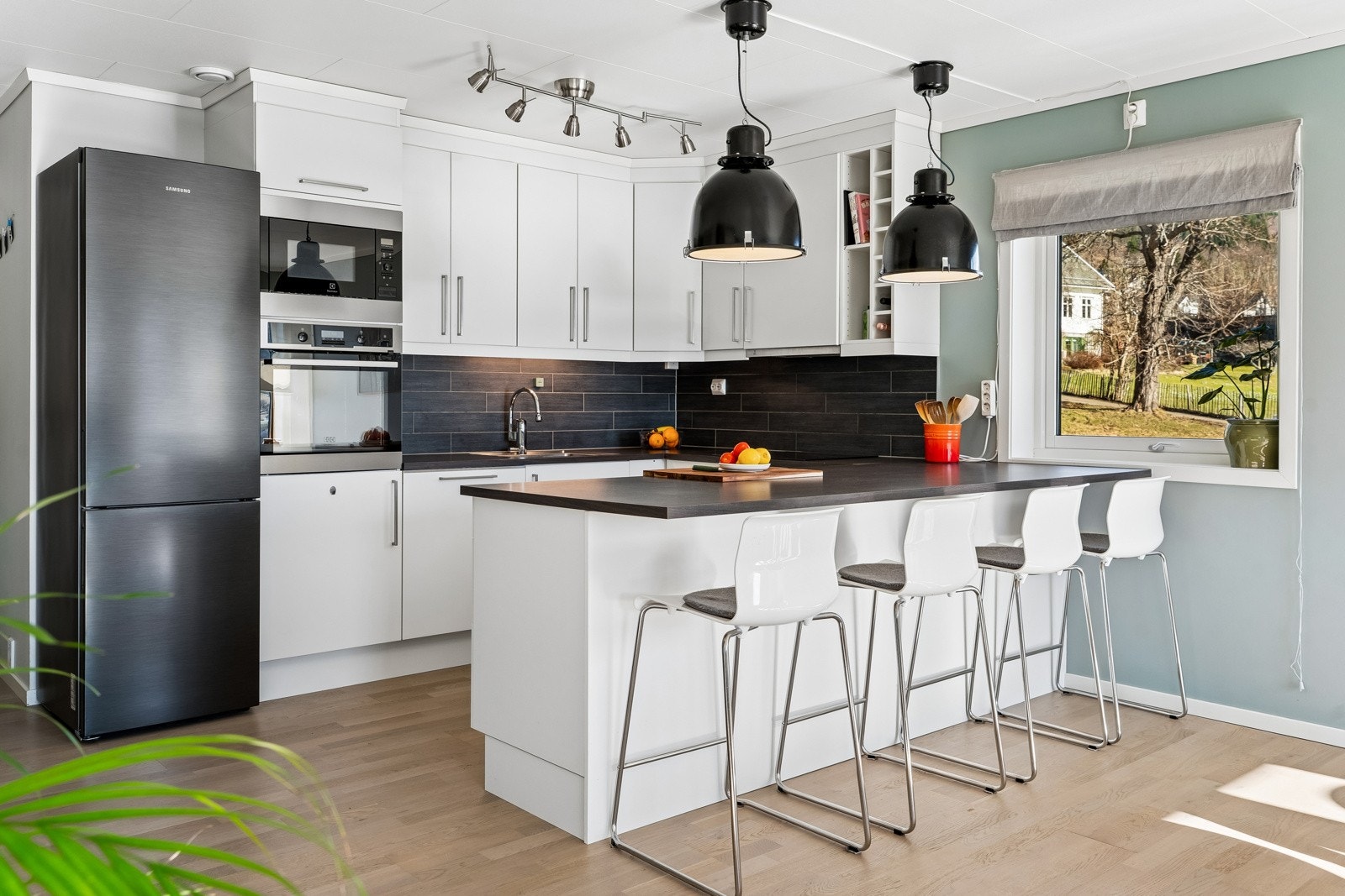 Tidlaus innreiing med takhøge overskap og kjøkkenøy med spiseplass i barløysing. Integrerte kvitevarer med: induksjonstopp, steikeomn, mikro og oppvaskmaskin Galleribilde