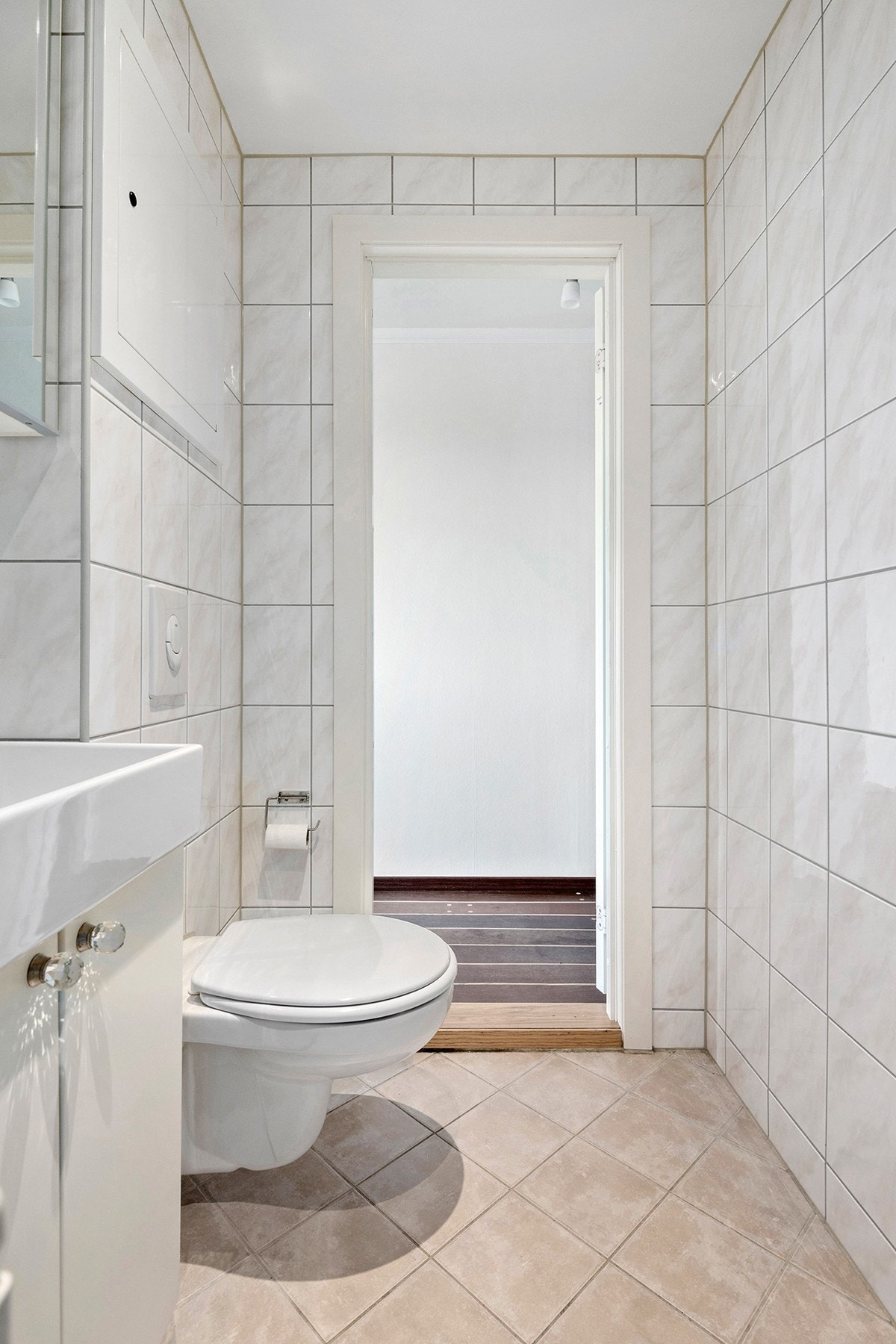 Bad - servantinnredning med skap, speilskap, åpen dusj på gulv, veggmontert wc og opplegg for vaskemaskin. Galleribilde