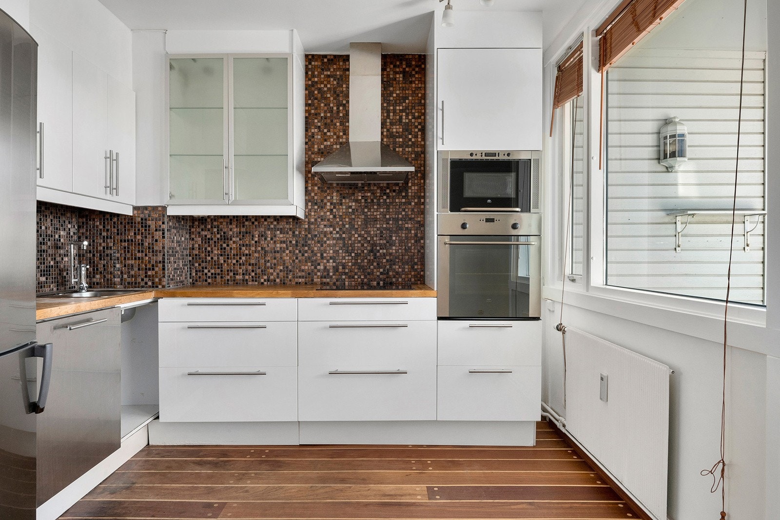 Kjøkken - innredning med slette høyglansede fronter og benkeplaten er av heltre Galleribilde