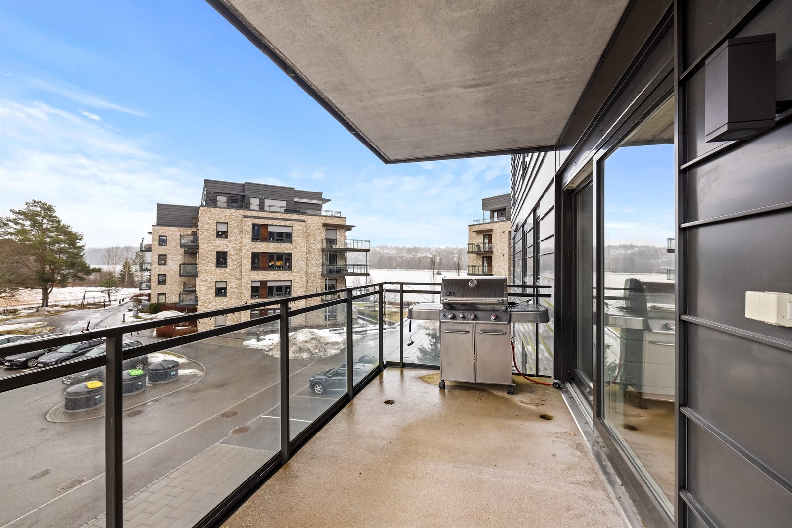 Balkongen har en solid betongkonstruksjon med et moderne rekkverk i metall og glass. Galleribilde