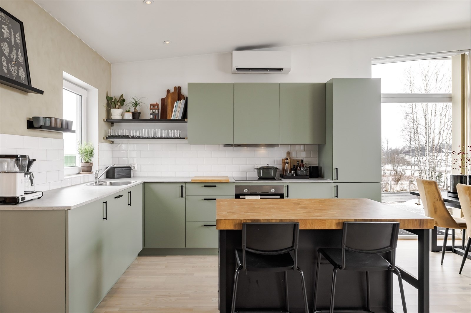 Som et fint midtpunkt i rommet er det en kjøkkenøy som gir ekstra god benkeplass og en hyggelig sitteplass med barstoler. Galleribilde