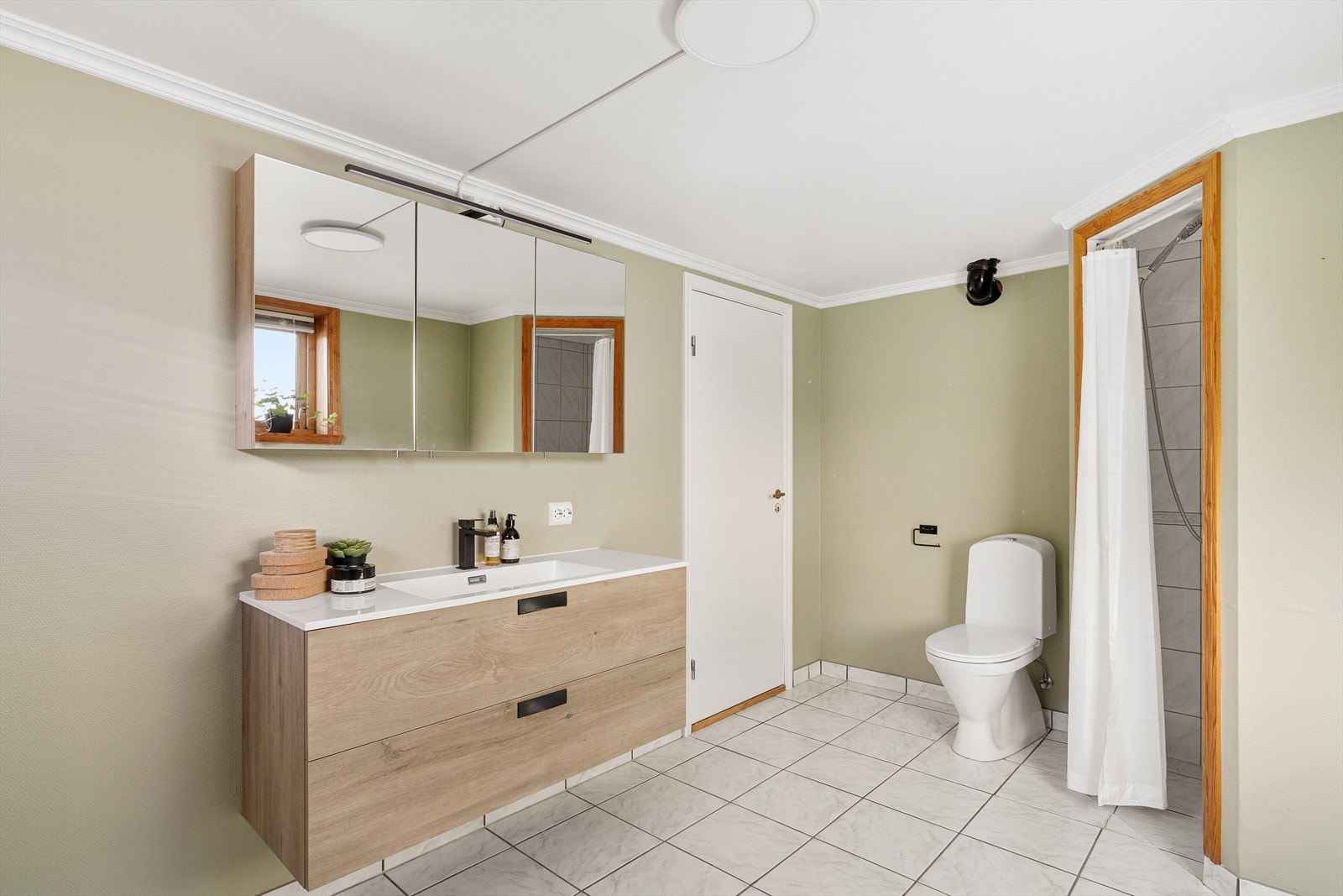 Bad i kjeller med fliser på gulv. Baderoms innredning med god oppbevaringsplass Galleribilde