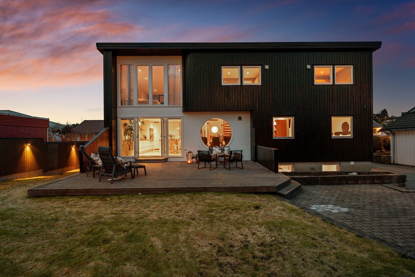 Pelt opparbeidet uteområde med markterrasse og plen. Utelysene på garasje, hagestue samt gjerde skaper en god atmosfære. Galleribilde