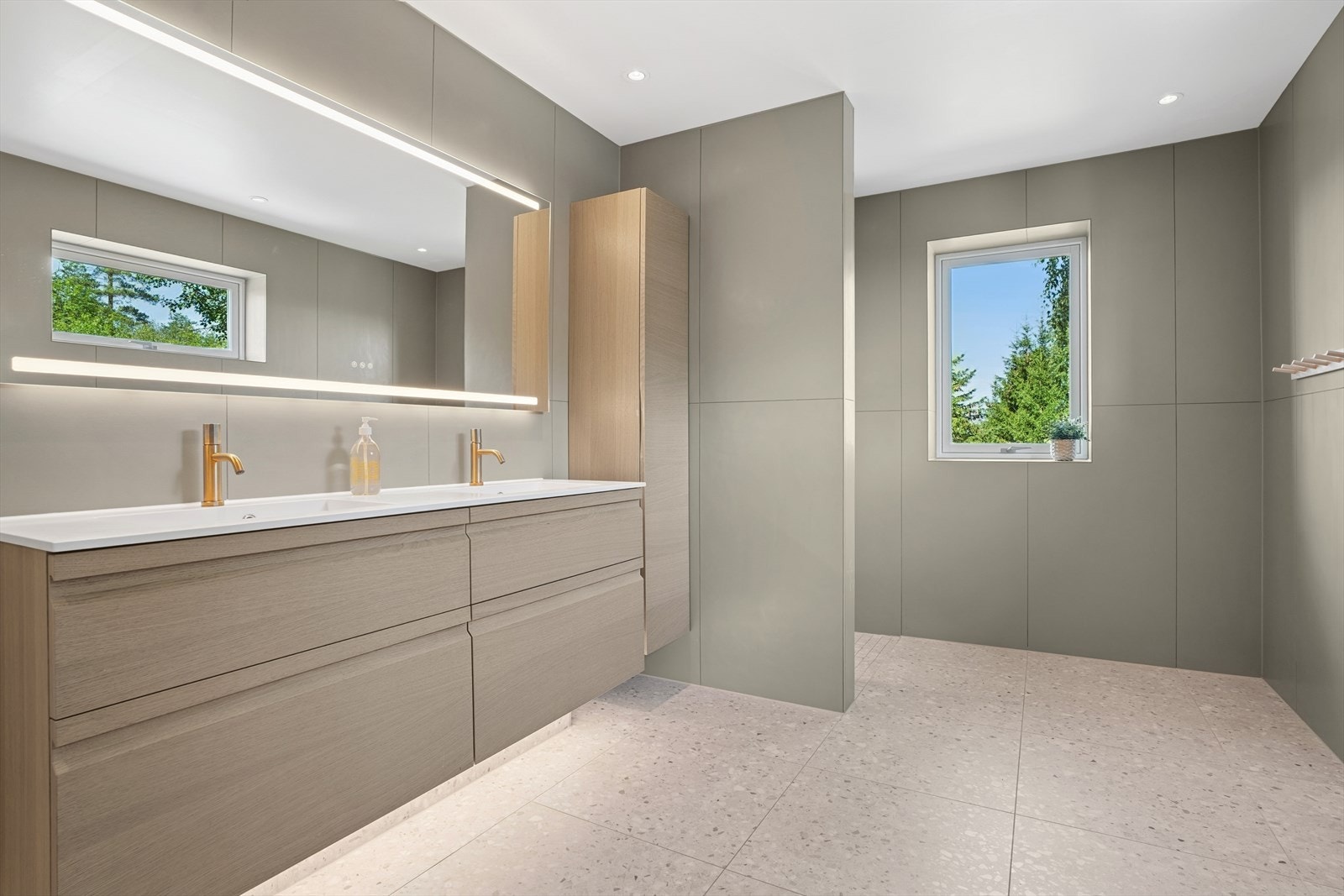 Badet i første etasje har dobbelt heldekkende servant med skuffer, høyskap, speil med integrert belysning og vegghengt toalett. Galleribilde