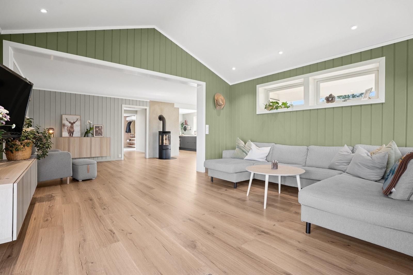 Stuen i første etasje skaper en perfekt arena for både avslappende stunder og sosiale sammenkomster med plass til både spisegruppe og sofa med tilhørende møblement. Galleribilde