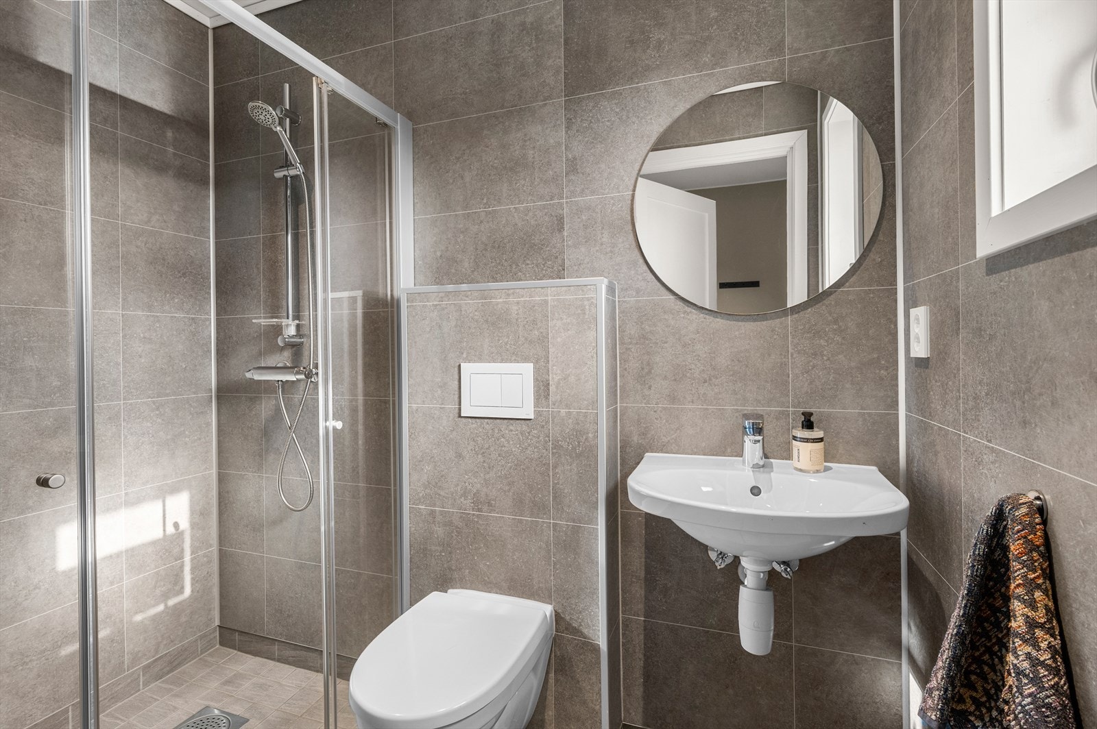 I hovedetasjen ligger ett av boligens to bad, utstyrt med vegghengt toalett og dusjnisje. Galleribilde