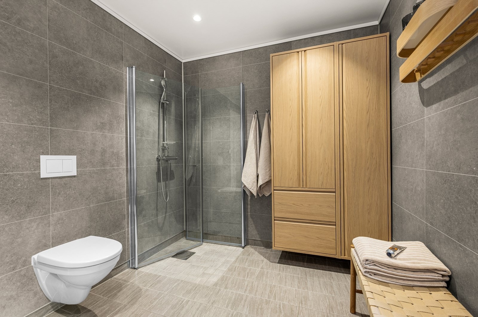 Videre er det montert vegghengt toalett, dusjhjørne og downlights i himling. Galleribilde