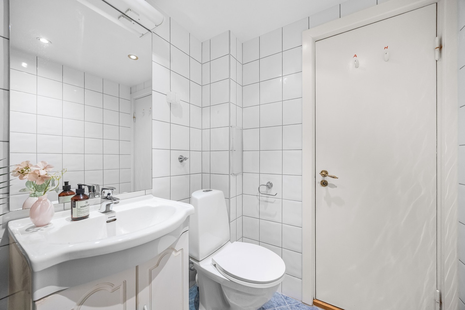 Badet er helfliset, med malte, slette himlingsflater, samt monterte downlights. Det er installert servantseksjon med skapdører og heldekkende servant og ett-greps blandebatteri, speil på vegg med lysarmatur og stikkontakt, veggskap med speil Galleribilde