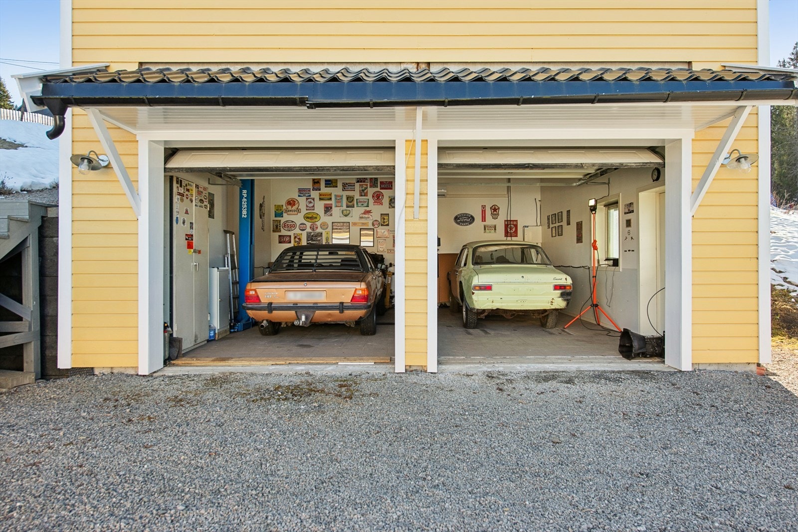 Den doble garasjen/verkstedet har to leddporter i metall og god takhøyde. Galleribilde