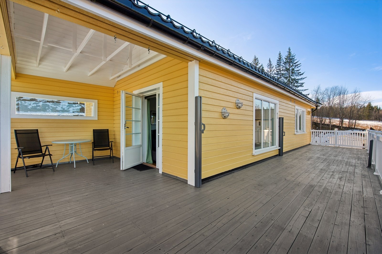 Terrassen strekker seg langs vestsiden og nordsiden av huset, og gir rikelig med plass for utemøbler. Galleribilde