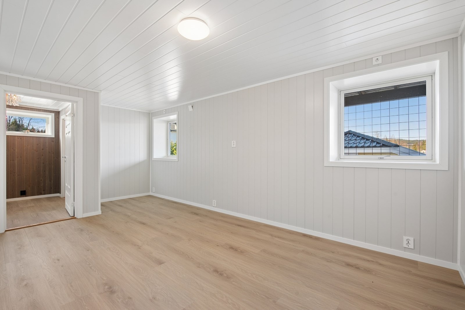 Rommet er lyst og delikat med laminat på gulv og panelplater på veggene. Galleribilde