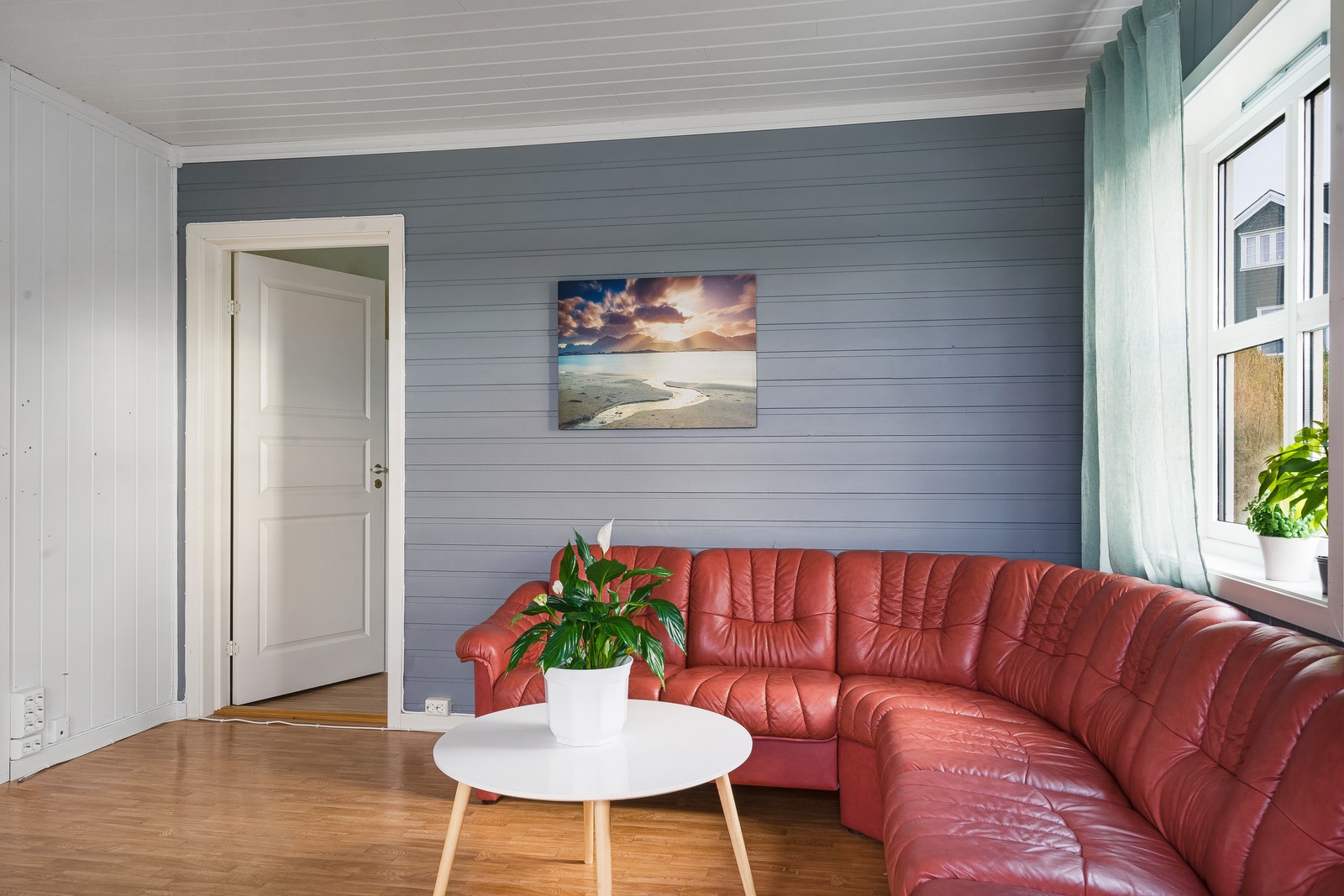 Trivelig sofaseksjon i stuen, med inngang til soverom i hovedetasjen. Galleribilde