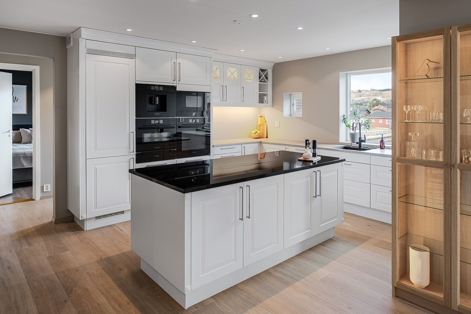 Kvalitetskjøkken fra Sigdal med benkeplate i stein på kjøkkenøy og laminat over kjøkkeninnredning. Integrert kjøleskap fra Bosch, Siemens oppvaskmaskin og platetopp fra røroshetta. Galleribilde