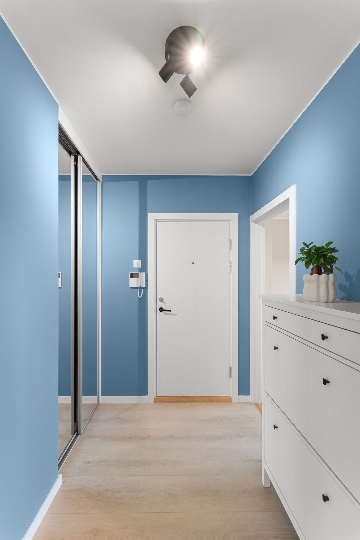 Entré med god plass til sko og oppheng av ytterklær i skyvedørsgarderobe med speildører Galleribilde