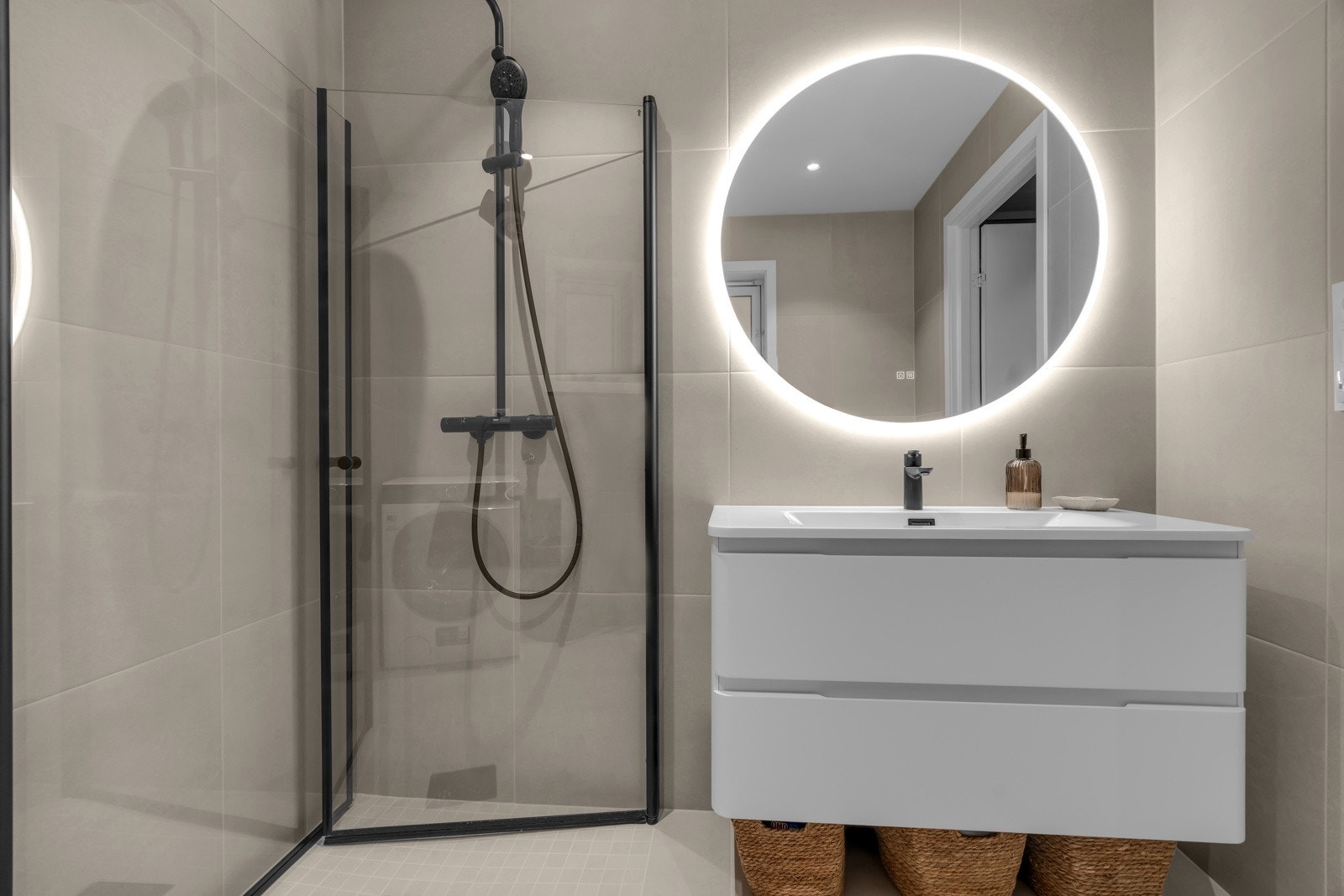 Badet har innfellbar dusj med sorte detaljer og pen innredning med lys i speil. Galleribilde