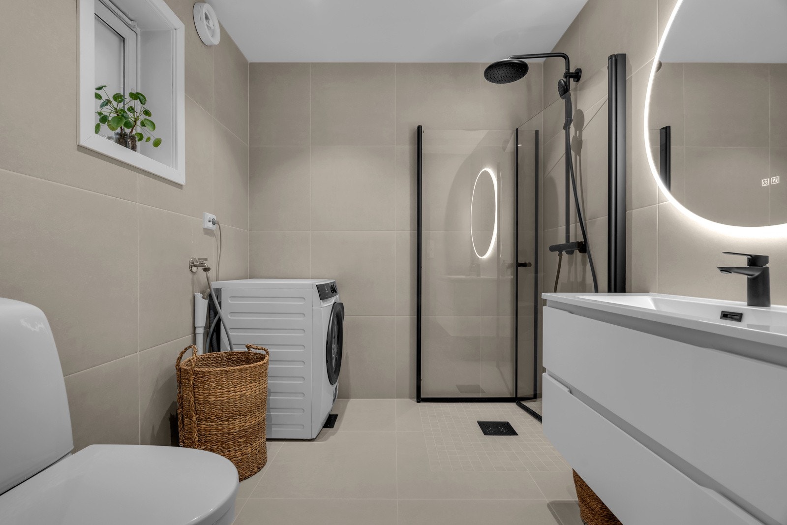 Badet er nyoppusset (2025) med 60*60 fliser på gulv og vegger samt moderne innredning med sorte detaljer og lys i speil. Galleribilde