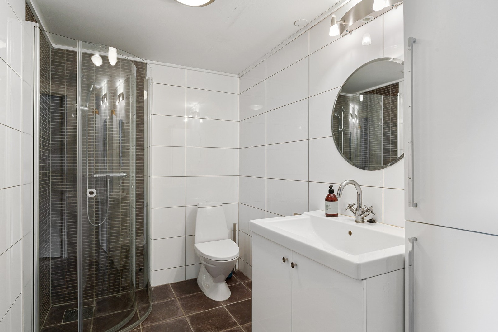 Boligen har hele 3 fullverdige bad. Dette er baderommet i 1.etasje. Helfliset og med varme i gulv. Galleribilde