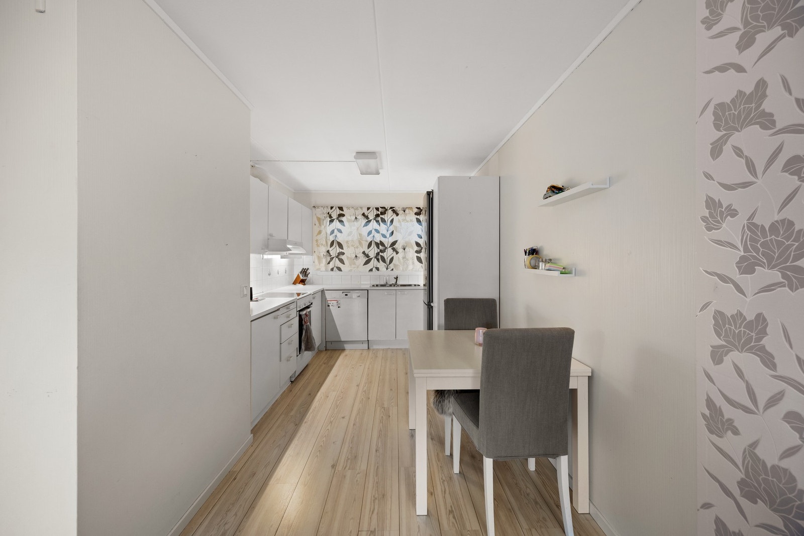 Stilren kjøkkeninnredning med integrert stekeovn, platetopp og oppvaskmaskin. Galleribilde