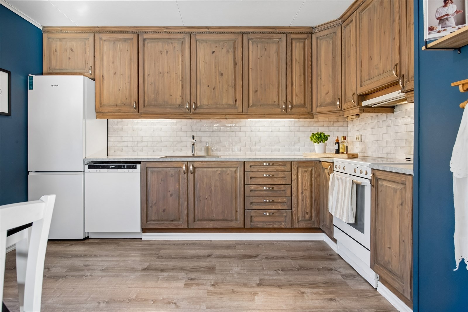 Kjøkkenet er et eget rom med en solid heltre innredning som har profilerte fronter og takhøye overskap. Galleribilde