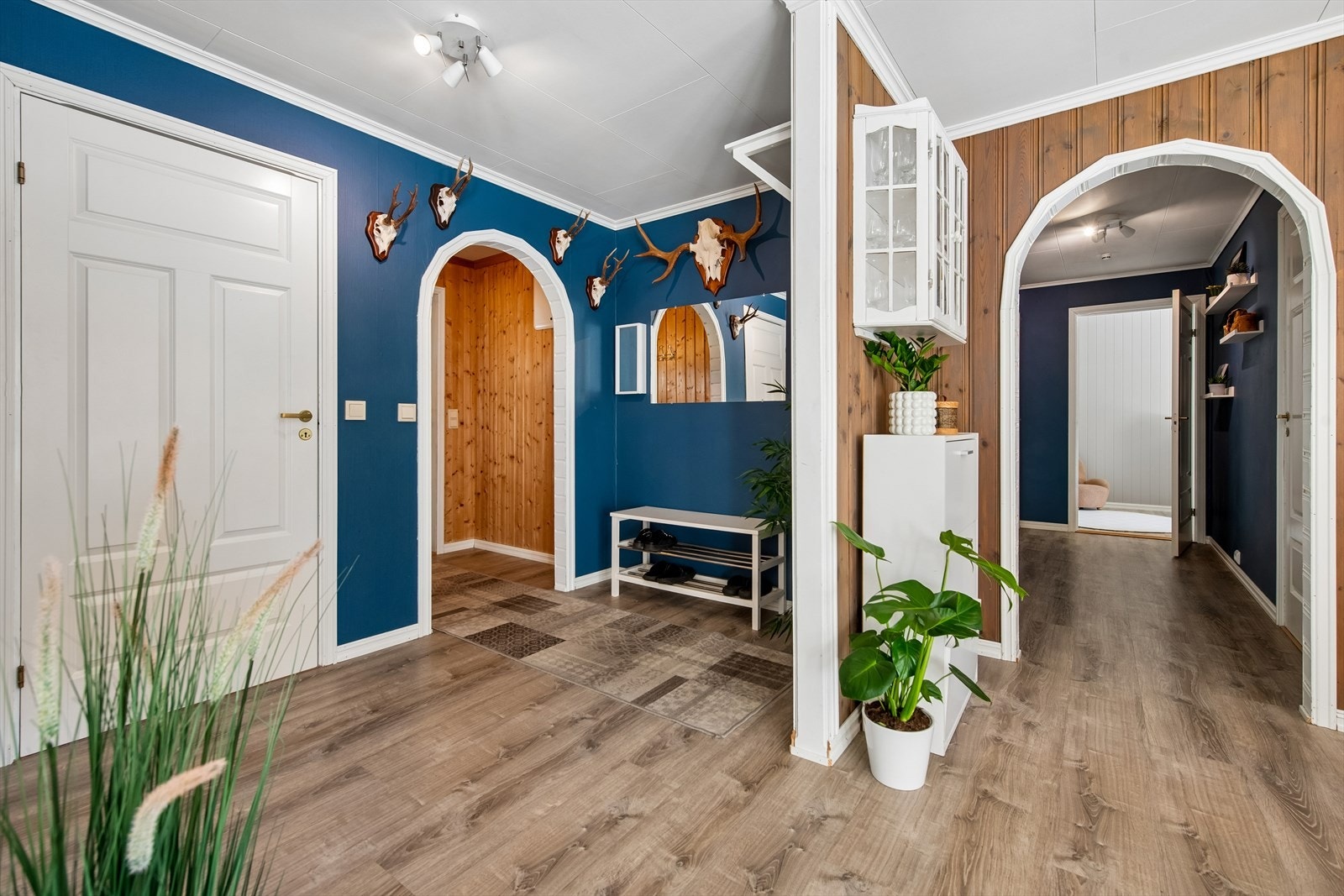 Hallen fungerer som et bindeledd i boligen, med adkomst til en praktisk innvendig bod. Galleribilde