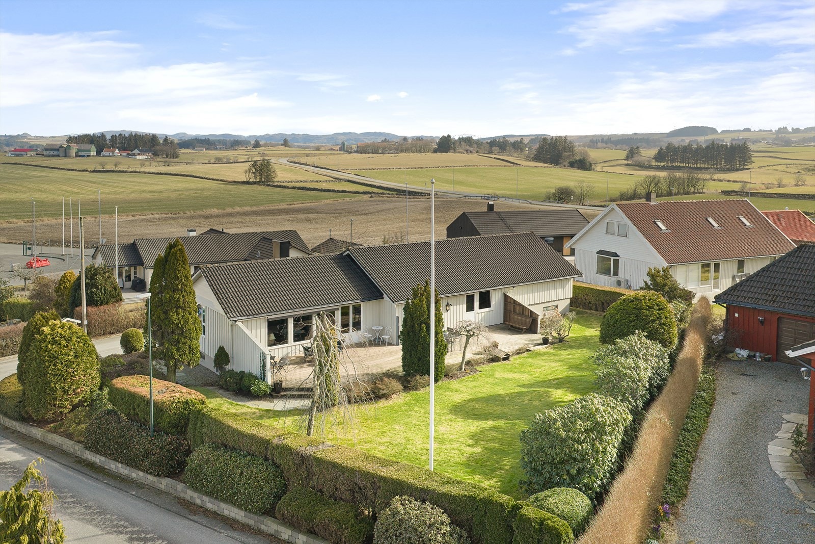 Eiendommen er pent opparbeidet med fin beplanting Galleribilde