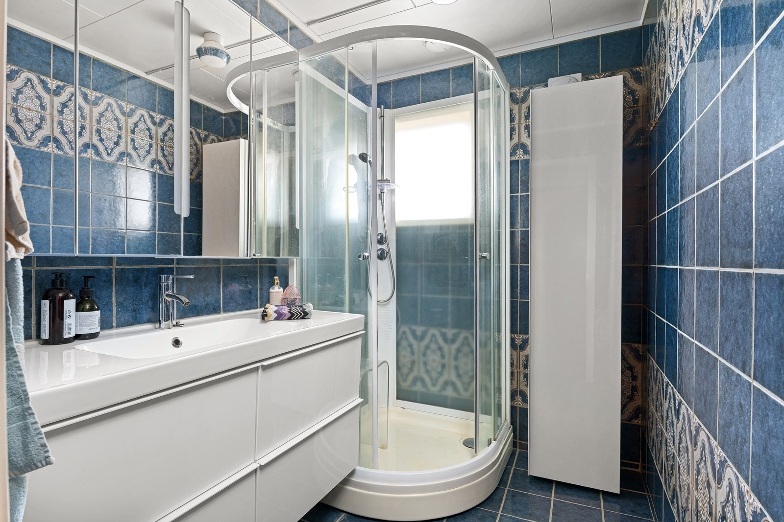 Helfliset bad med nyere dusjkabinett og servant med skuffeinnredning. Galleribilde