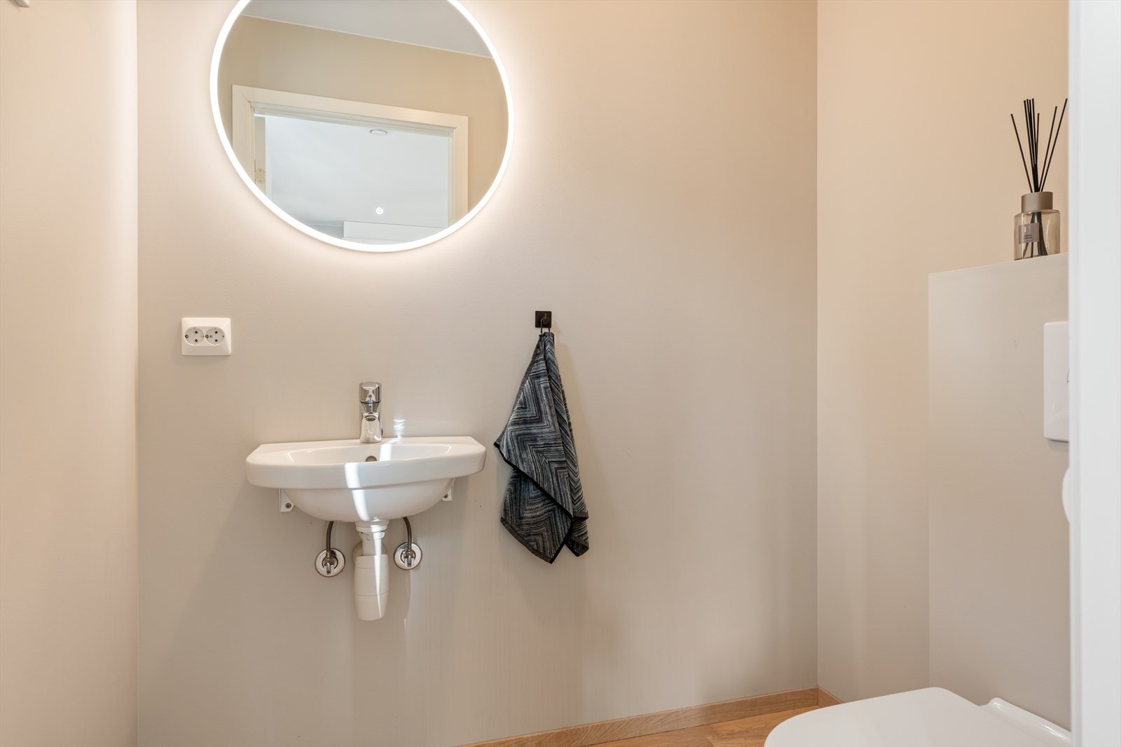 I den øverste etasjen finner du også en pent gjestetoalett som er innredet med enkel servant og vegghengt toalett Galleribilde