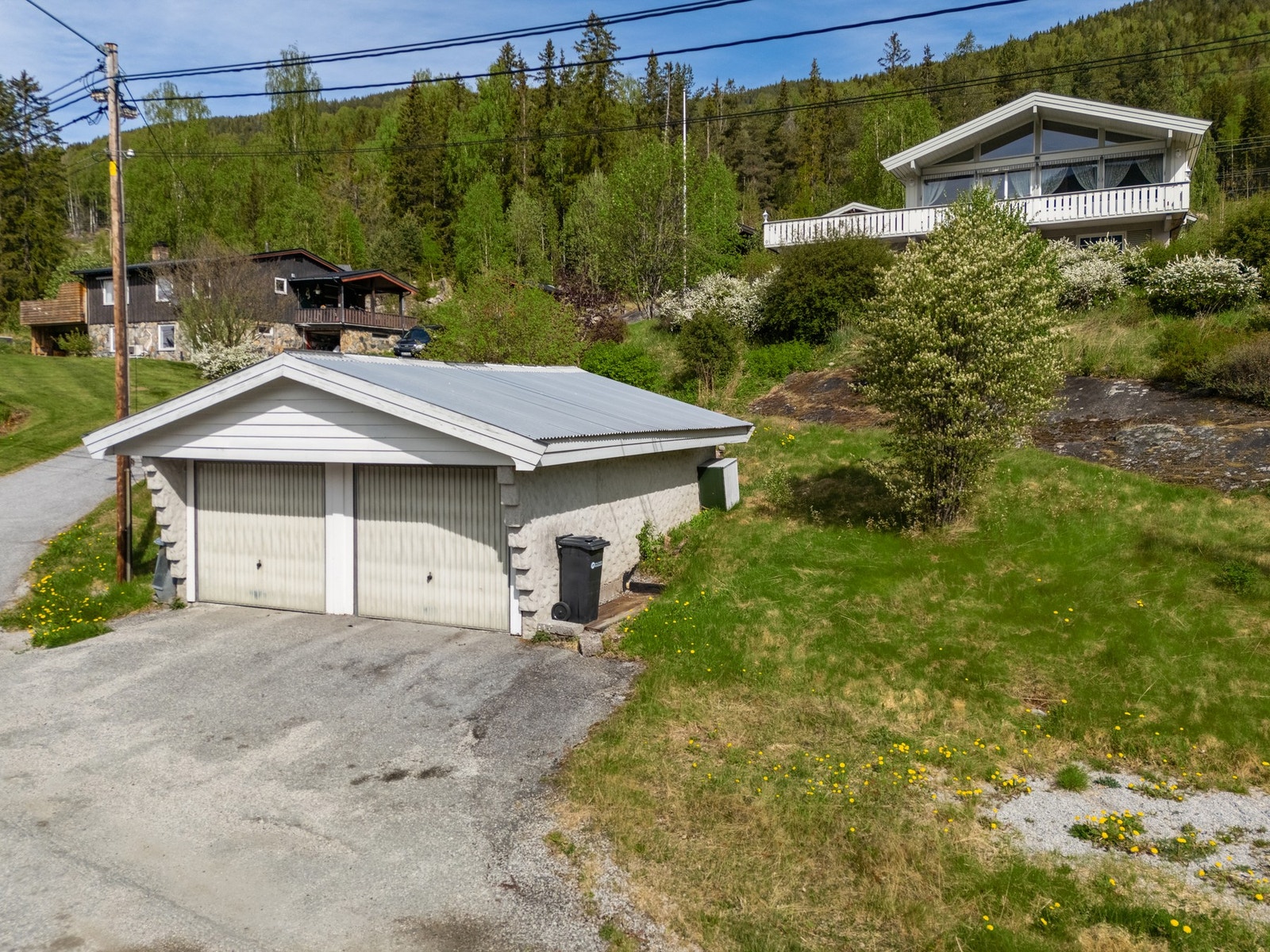 Dobbel garasje nede ved veien, i tillegg til carport i tilknytning til boligen Galleribilde