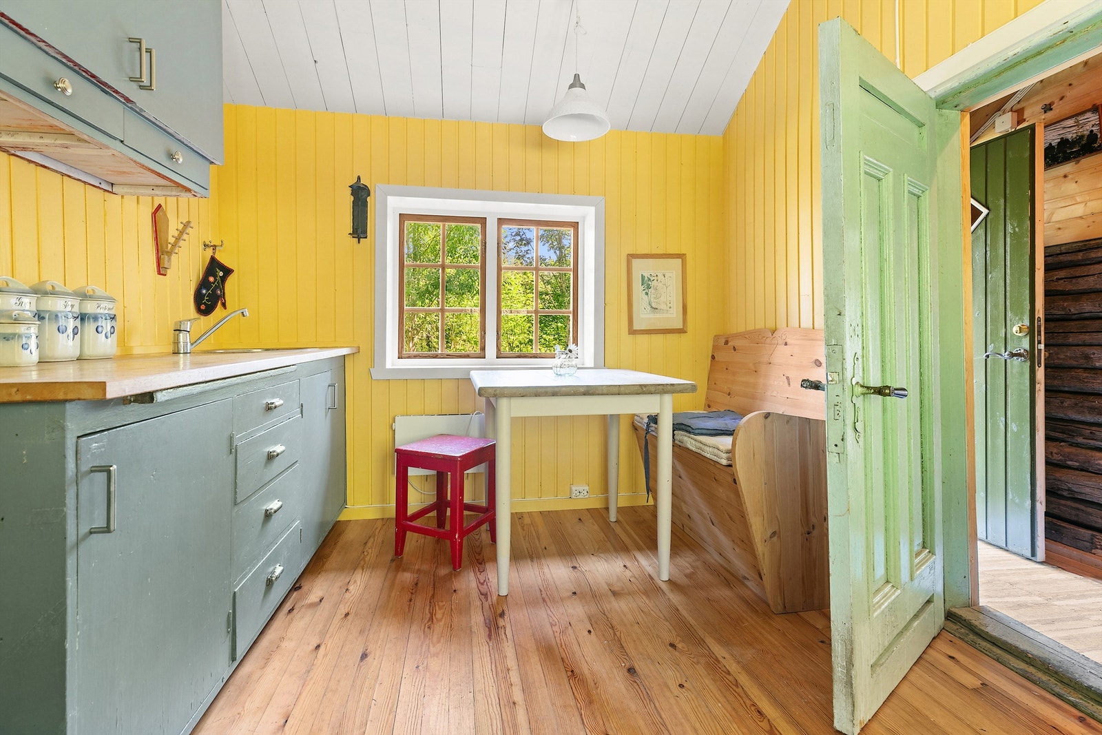 Eldre lite kjøkken med vedfyrt komfyr Galleribilde