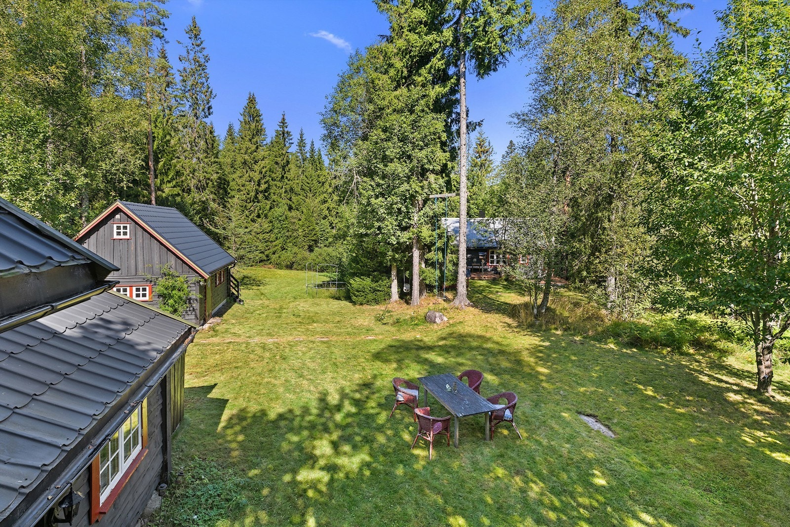 Tunet med to hytter og en garasje, stor tomt bestående av to gnr og bnr. Galleribilde