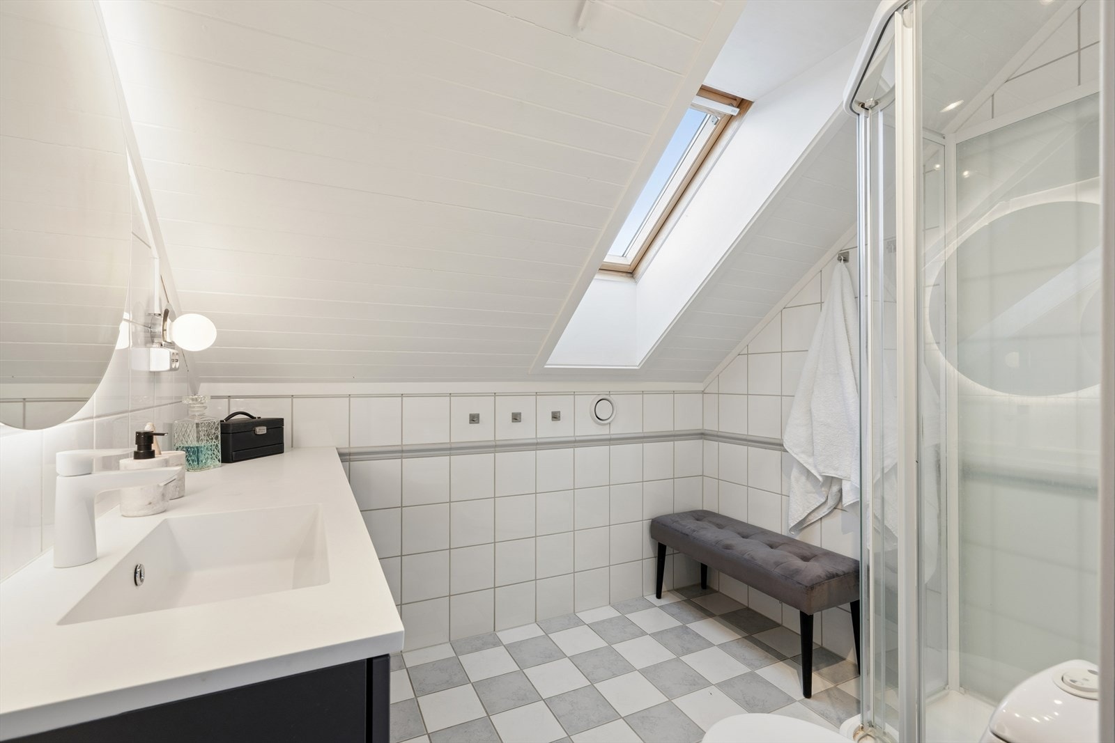 Badet på loftet er flislagt og har elektriske varmekabler i gulvet og takvindu som gir flott naturlig lys inn. Galleribilde