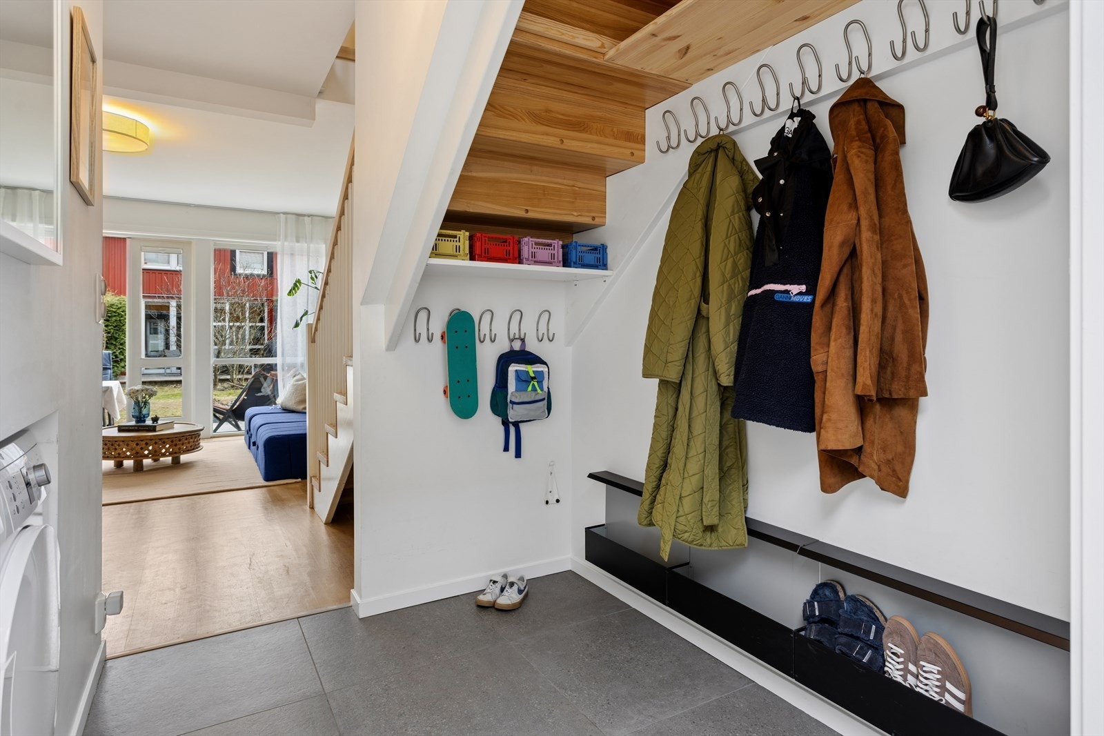 Innbydende entré med store, delikate fliser på gulv og behagelig gulvvarme som gir en god velkomst. Gangen har smarte oppbevaringsløsninger med praktisk klesoppheng, som bidrar til en ryddig og funksjonell hverdag. Galleribilde