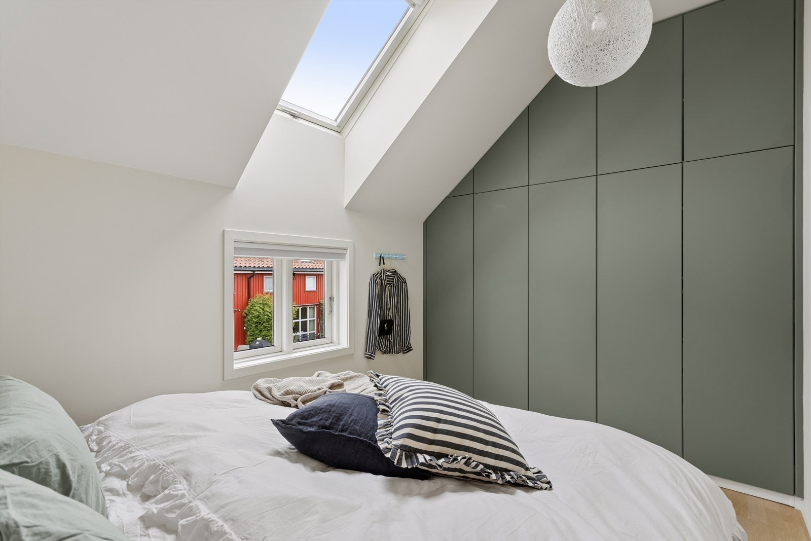 Langs den ene veggen er det en romslig og stilren garderobeløsning med glatte fronter, som gir svært gode oppbevaringsmuligheter og bidrar til et ryddig og helhetlig uttrykk. Galleribilde